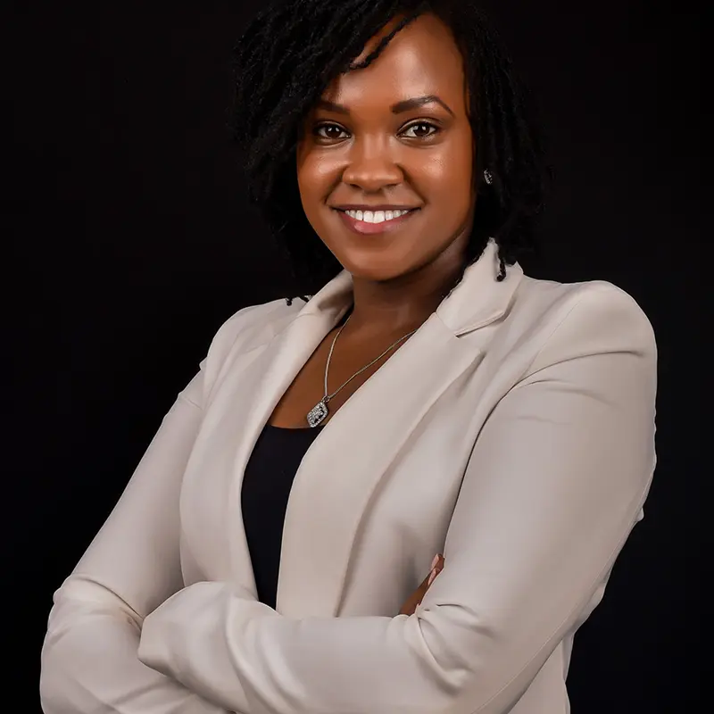 Dr. Wangui Waithaka smiling in a professional portrait, representing her dual role as a skilled plastic surgeon and compassionate partner in every patient's aesthetic journey.